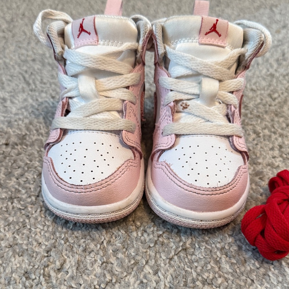 Jordan Ones Nikes Kids Pink and White Sneakers with red shoe laces too.